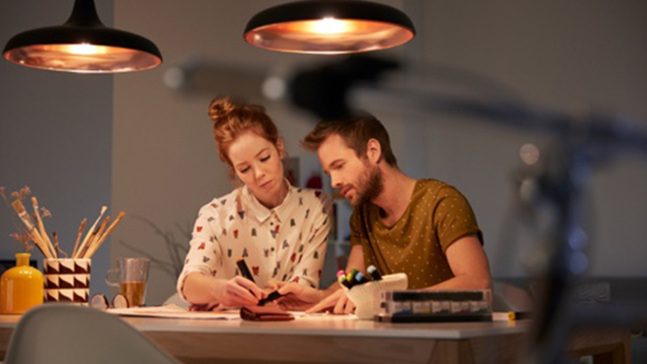 Två personer som skapar en ljusplan vid ett välupplyst skrivbord 