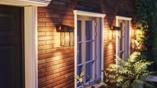 Modern LED-vägglampa för utomhusbruk belyser rustik träexteriör och visar energieffektiva och väderbeständiga belysningslösningar för moderna hemfasader och verandor.